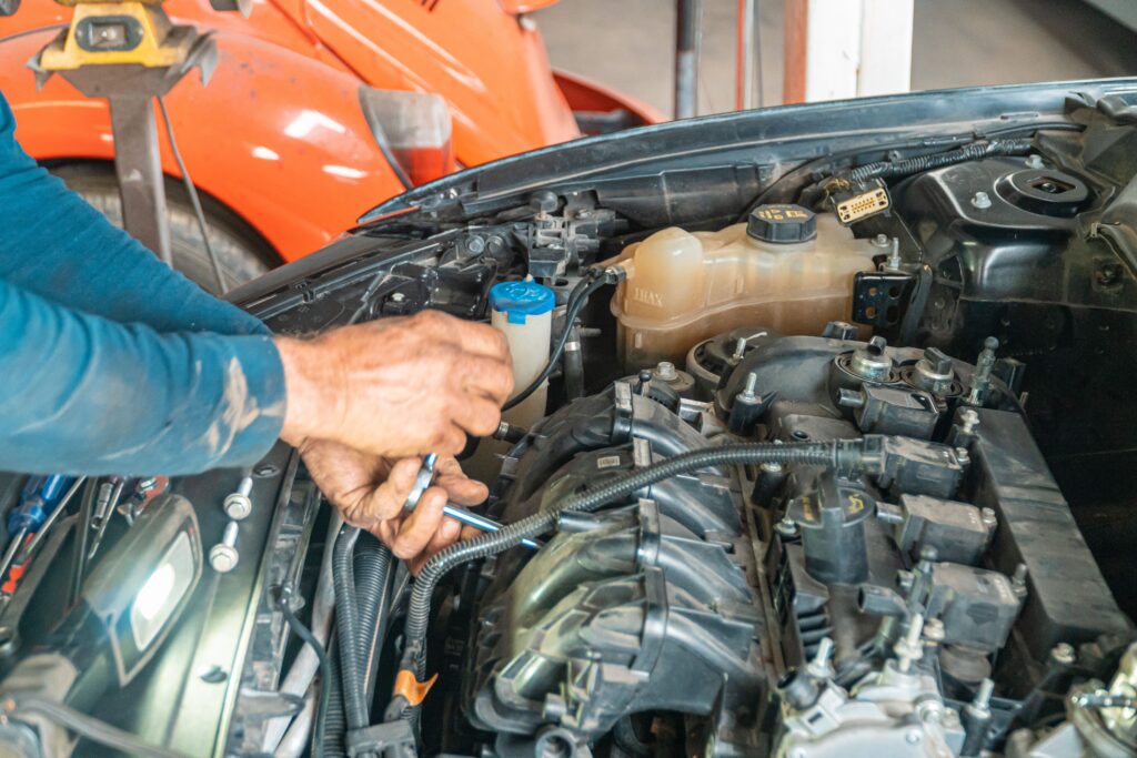A professional technician servicing vehicle engine components and fluid reservoirs at a Redmond Washington European auto repair shop